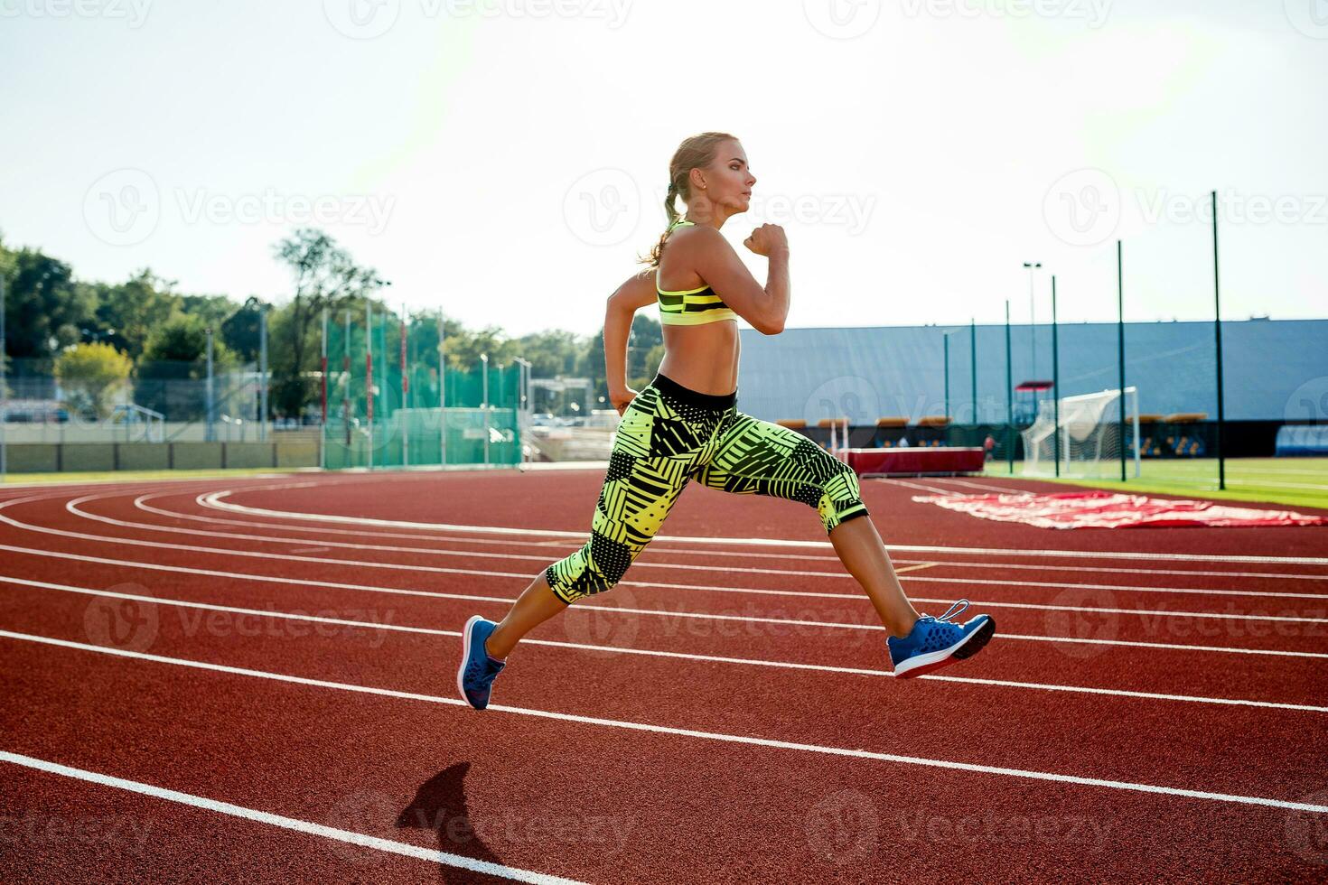 Beautiful young woman exercise jogging and running on athletic track on stadium. photo