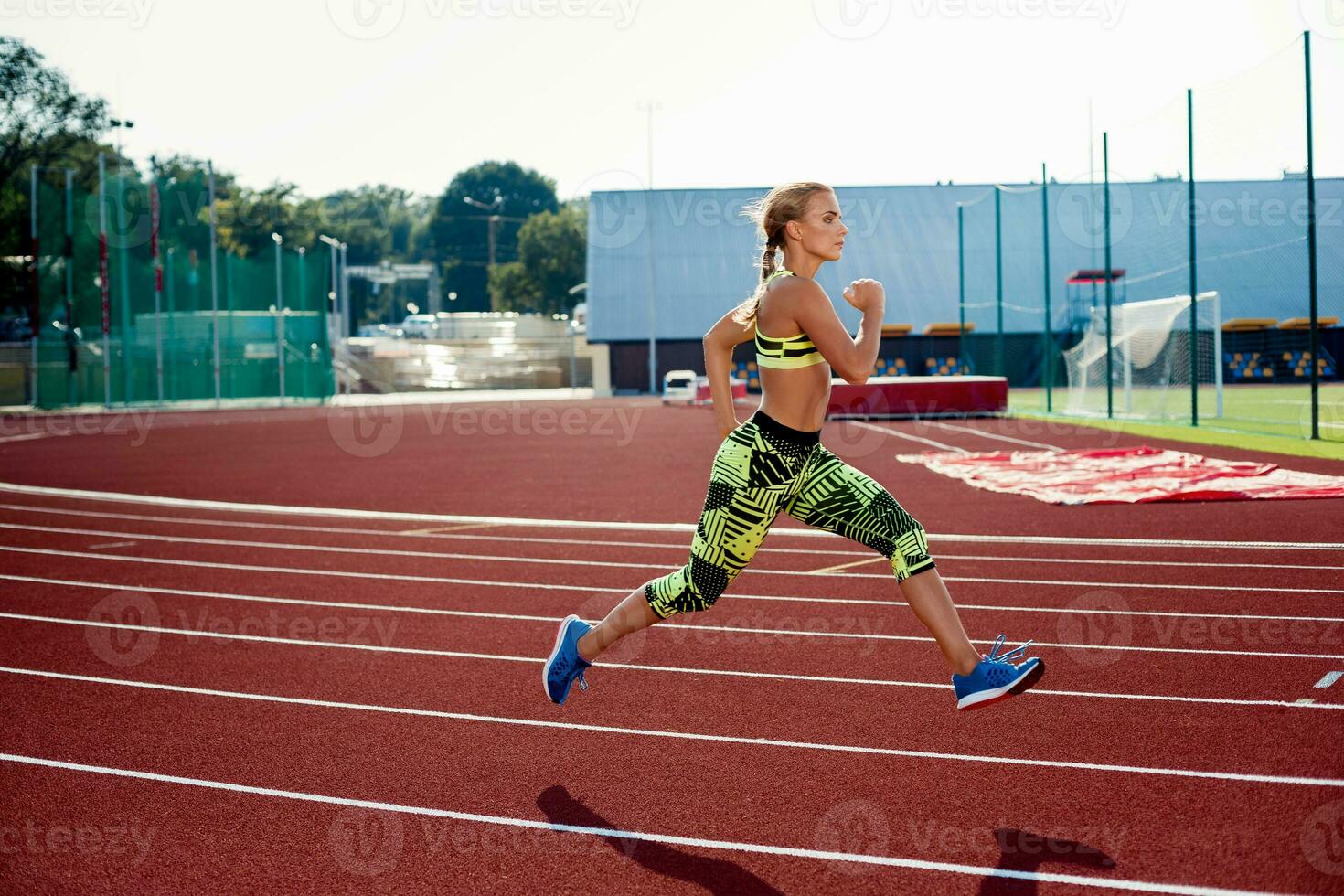 Beautiful young woman exercise jogging and running on athletic track on stadium. photo