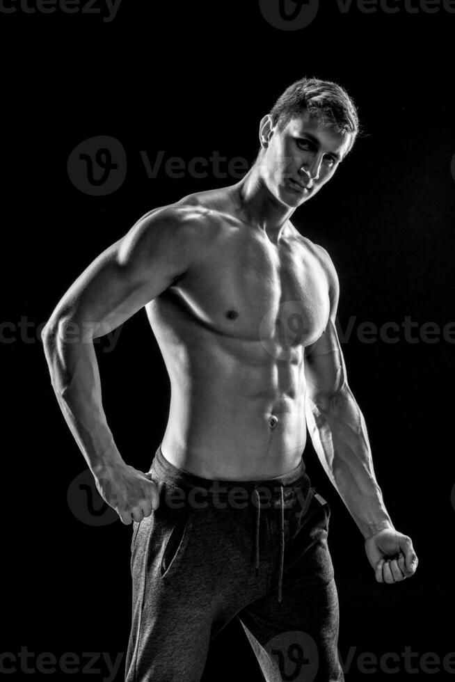 Strong man showing perfect abs, houlders, biceps, triceps and ch photo