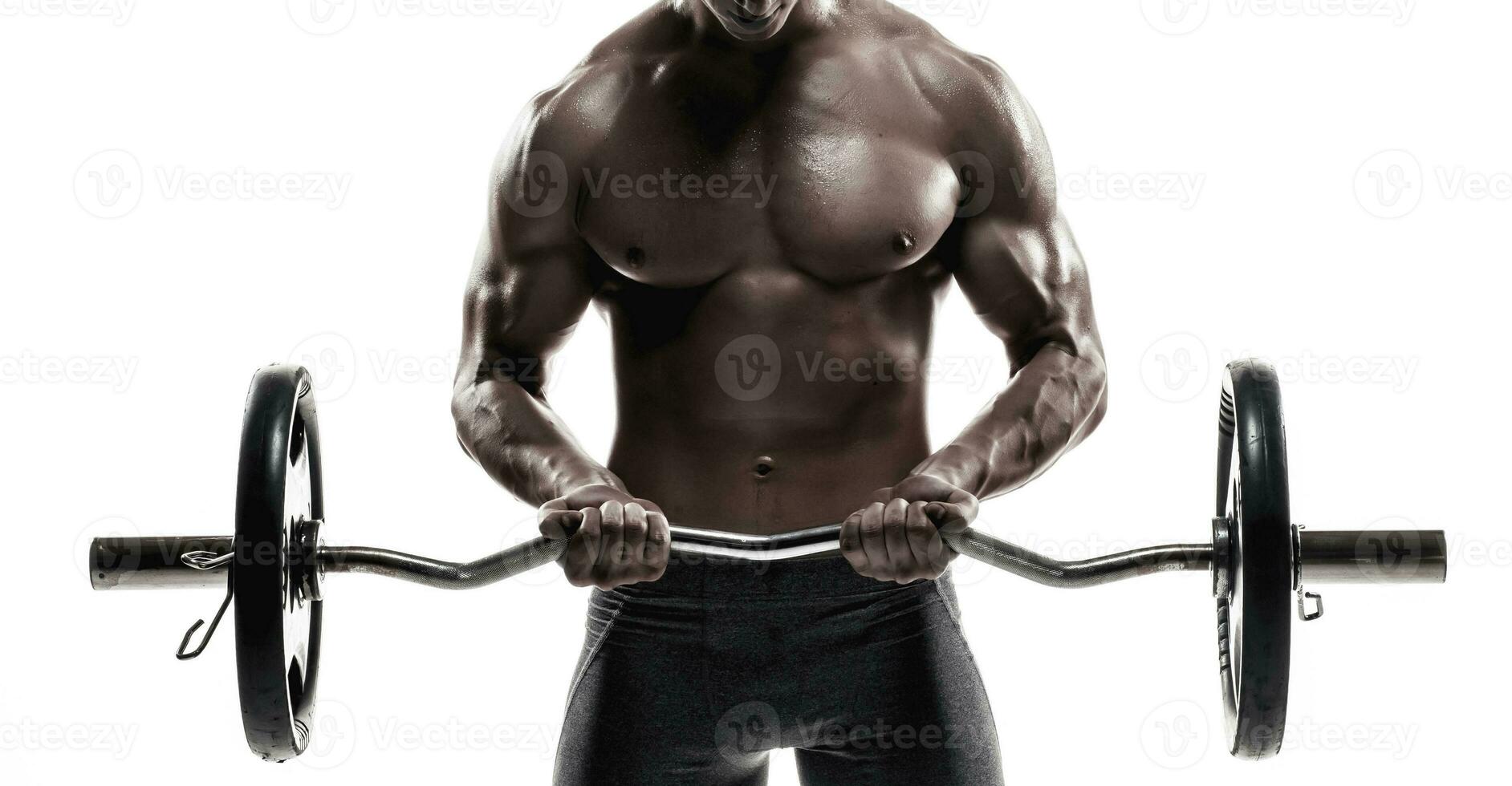 Young handsome man with naked torso and barbell photo