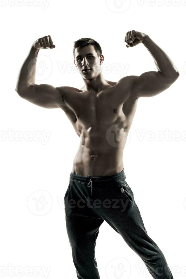 Muscular man posing, flexing his biceps, showing perfect body. photo