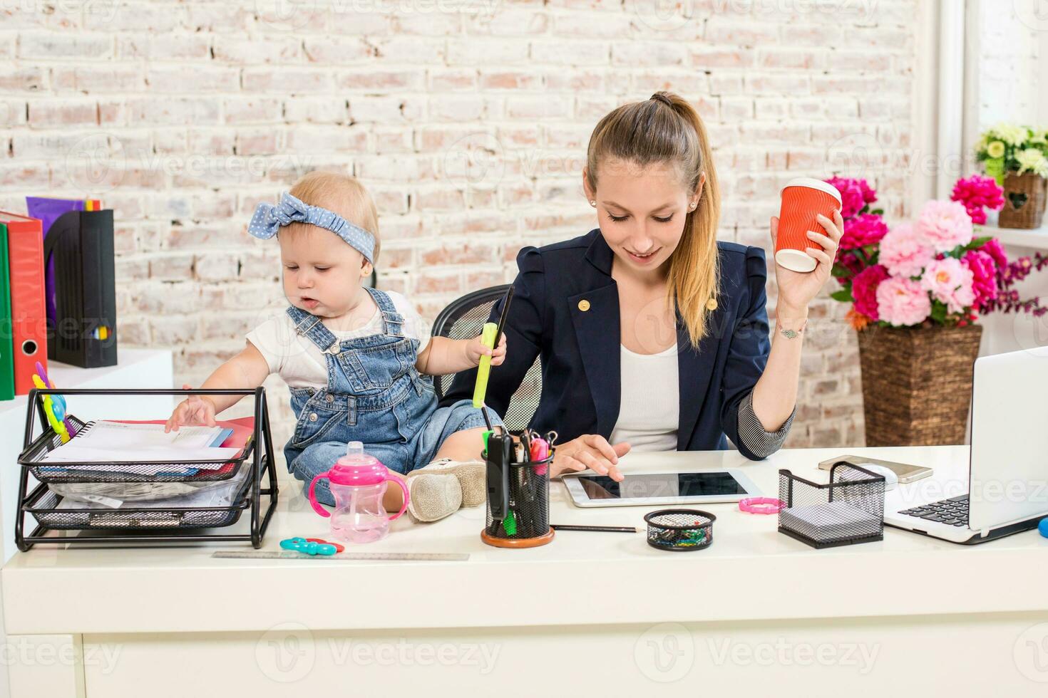 Mom and businesswoman working with laptop computer at home and playing with her baby girl. photo