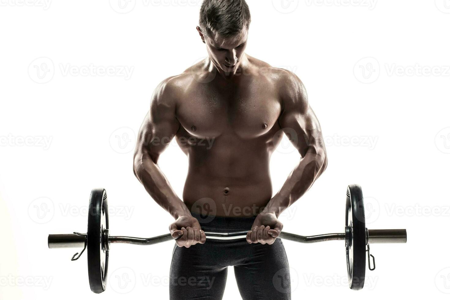 Young handsome man with naked torso and barbell photo