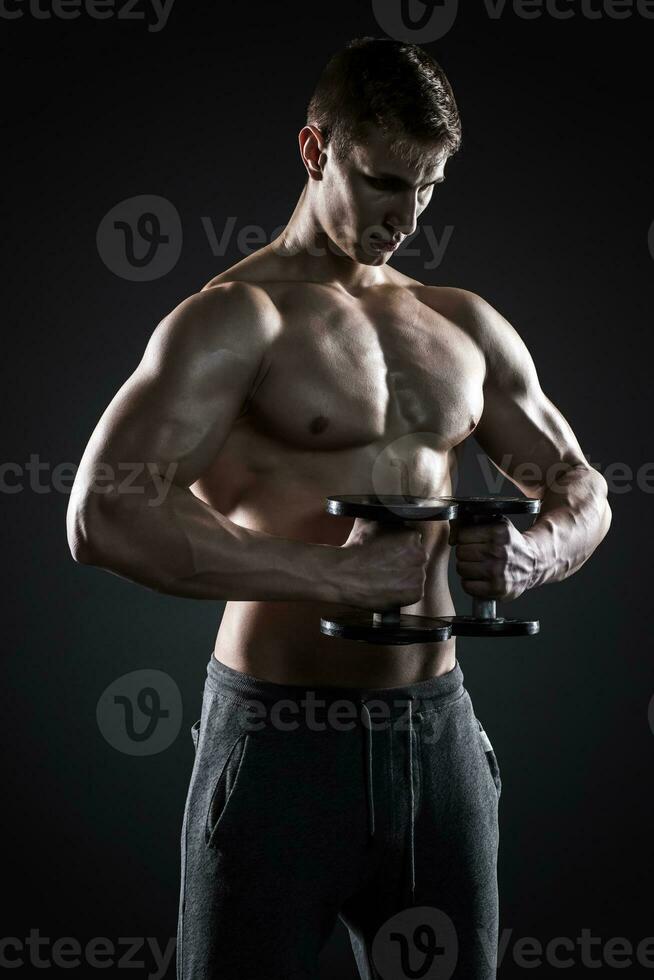 Mighty fitness man showing his gread body with dumbbells photo