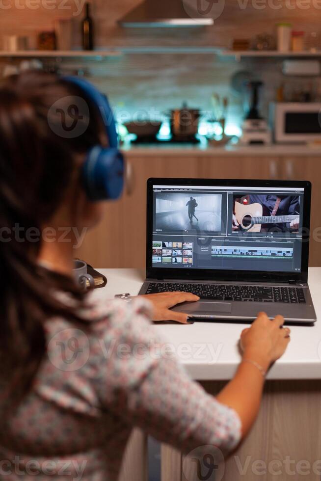 Filmmaker editing video footage in home using modern technology. Content creator in home working on montage of film using modern software for editing late at night. photo