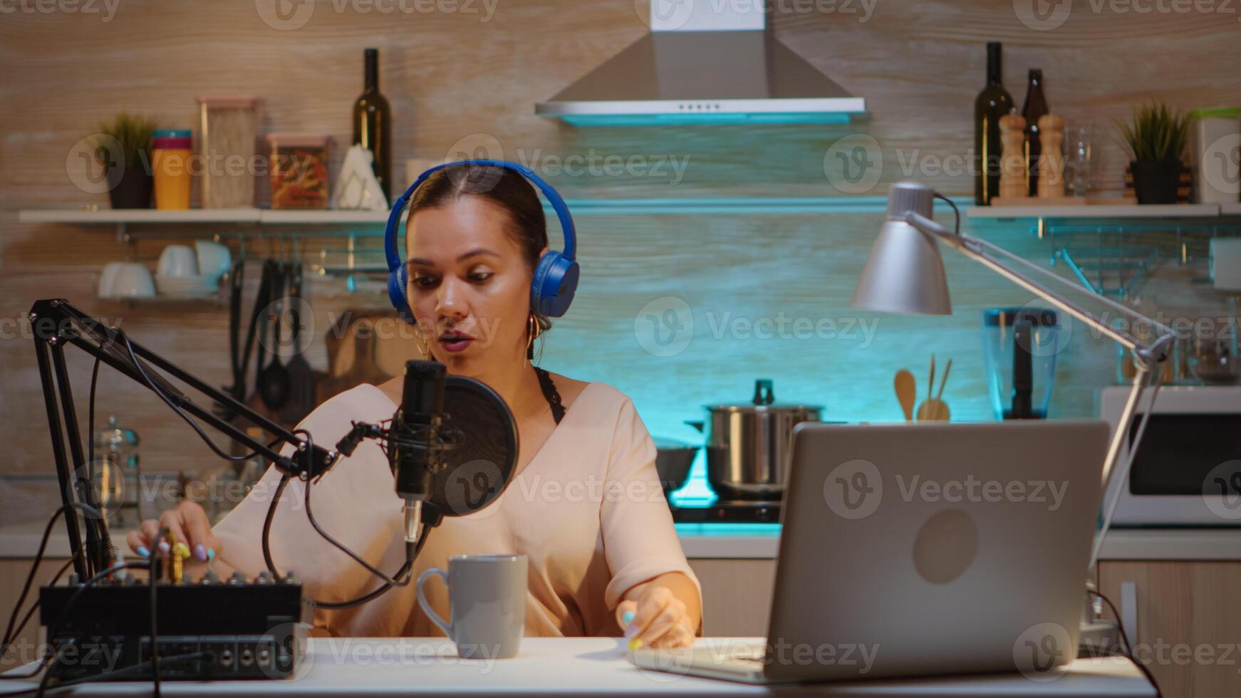 Talking on professional microphone during vlog recording in kitchen. Onair online production internet broadcast show host streaming live content, recording digital social media communication photo