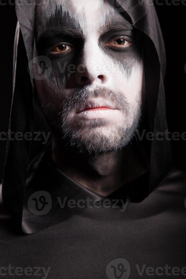 Close up portrait of grim reaper isolated over black background. Halloween costume. photo