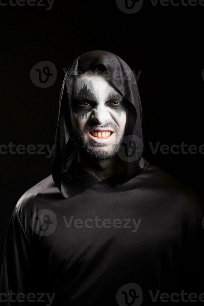 Grim reaper with a scary face isolated over black background. Evil face. photo