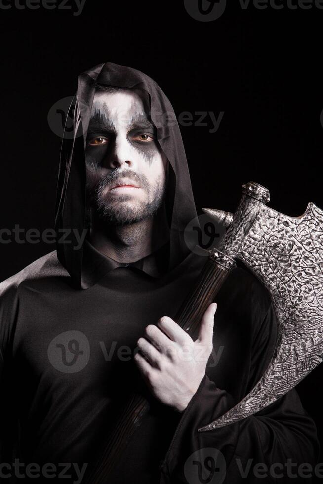 Dangerous grim reaper with a rope holding an axe over black background. photo