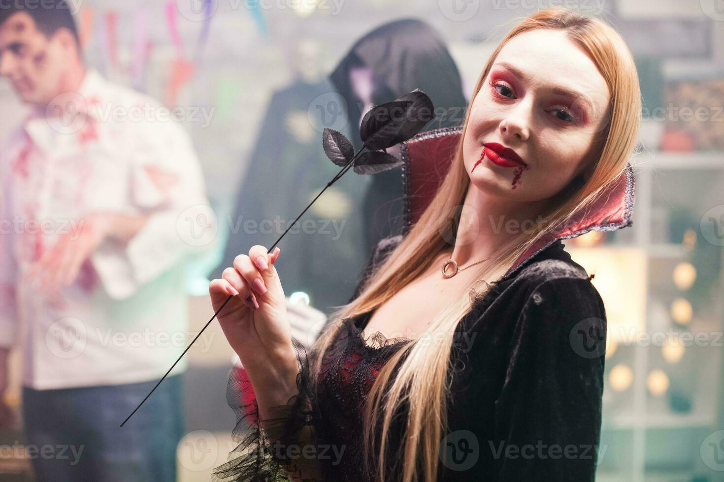 Woman wearing a vampire costume looking at the camera for halloween celebration. photo