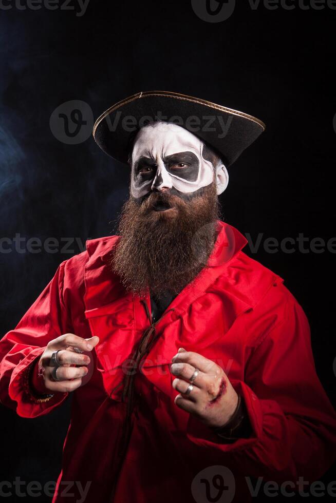 Man with long beard dressed up like medieval pirate over black background for halloween. photo