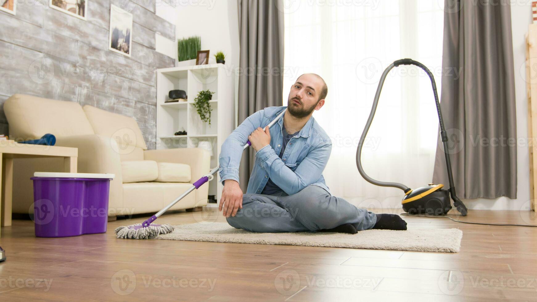 Tired husband after mopping the floor in apartment. photo