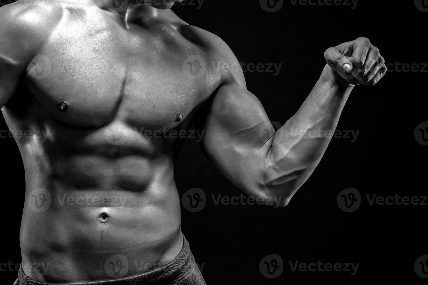 de cerca de hombre flexionando demostración su tríceps, bíceps músculos foto
