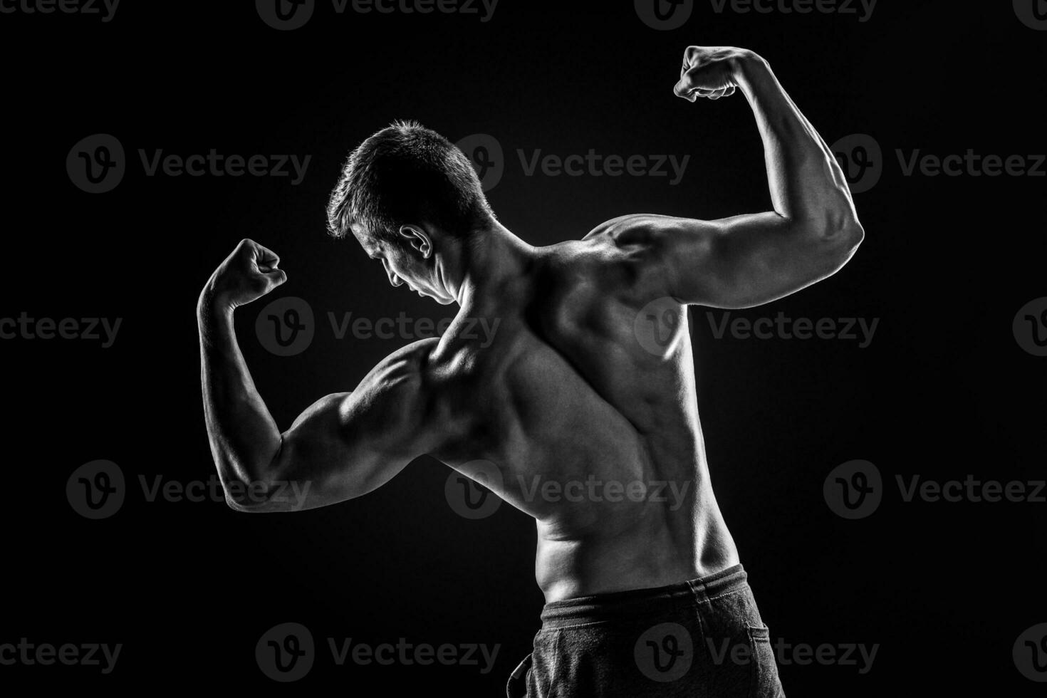 posterior ver de muscular joven hombre demostración atrás, bíceps músculos foto