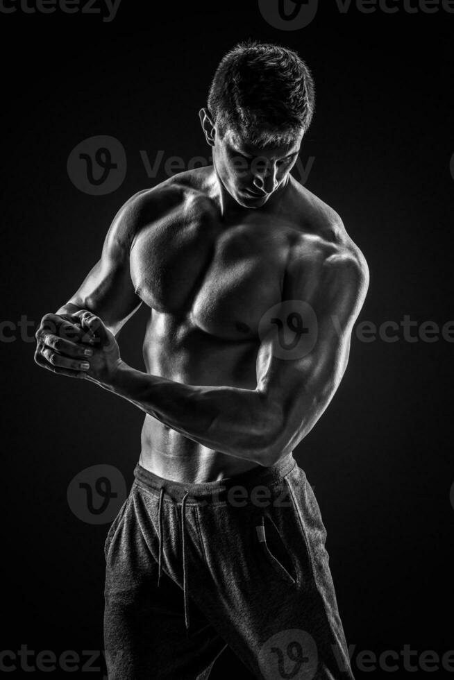 deportivo sano hombre posando y demostración su Perfecto cuerpo foto