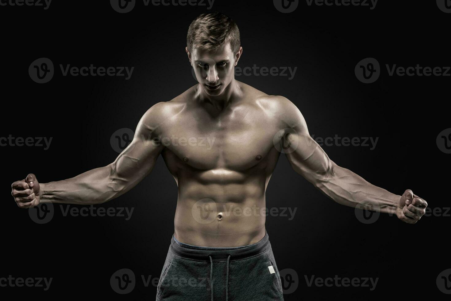 Stunning muscular man showing perfect abs, shoulders, biceps, triceps, chest photo