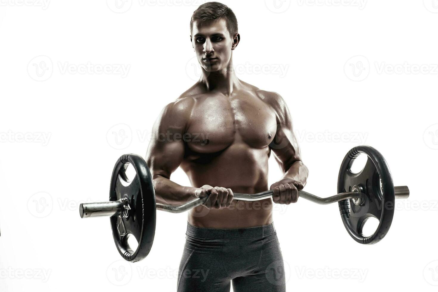 Young handsome man with naked torso and barbell photo