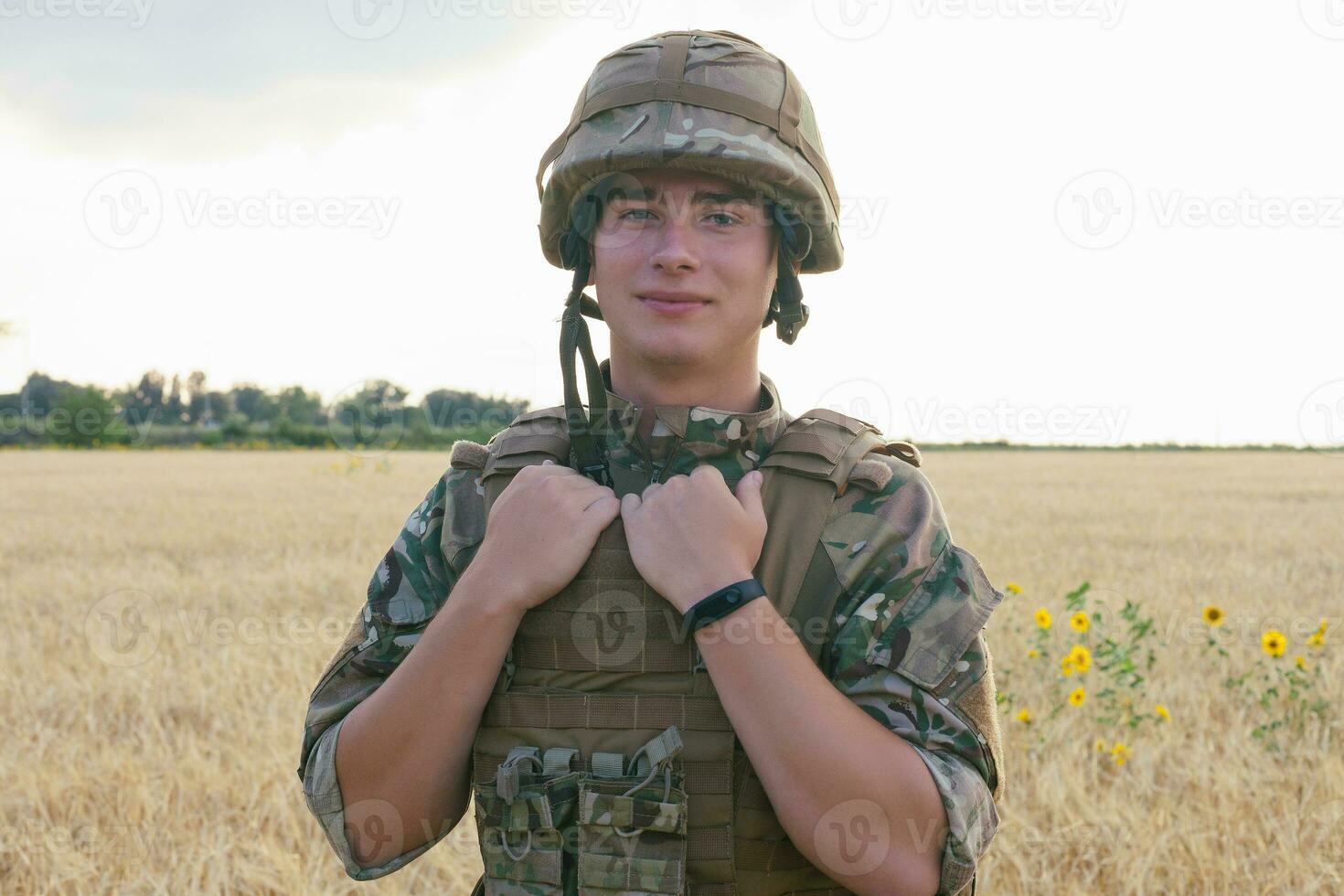 Soldier man standing against a field photo