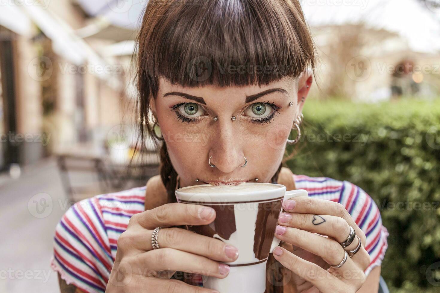 young woman with blue eyes gets her lips dirty with cream photo