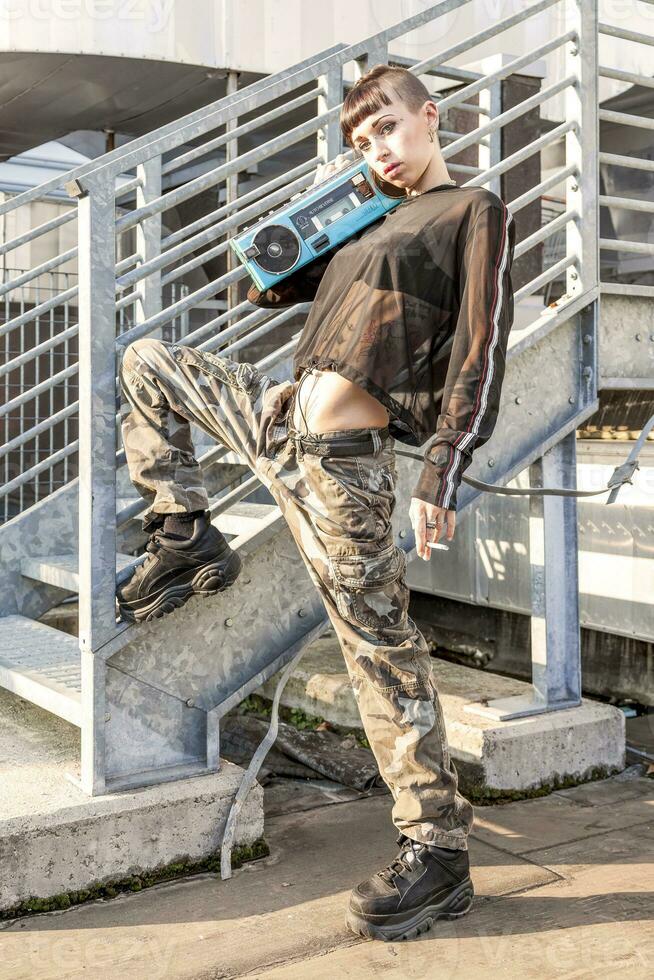 young female singer rap caucasian tattooed posing with a radio photo