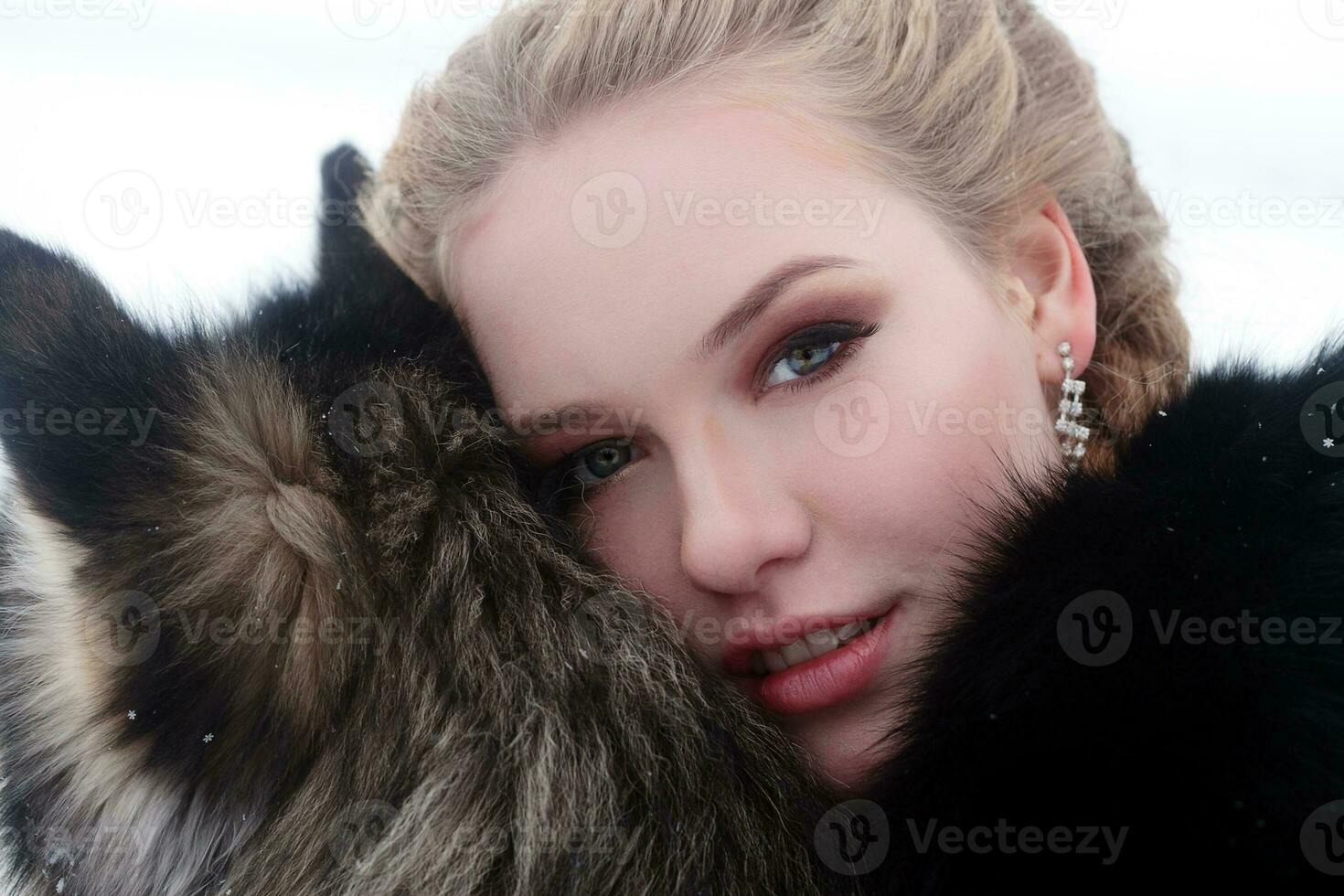 Young woman with wolf dog in snow photo