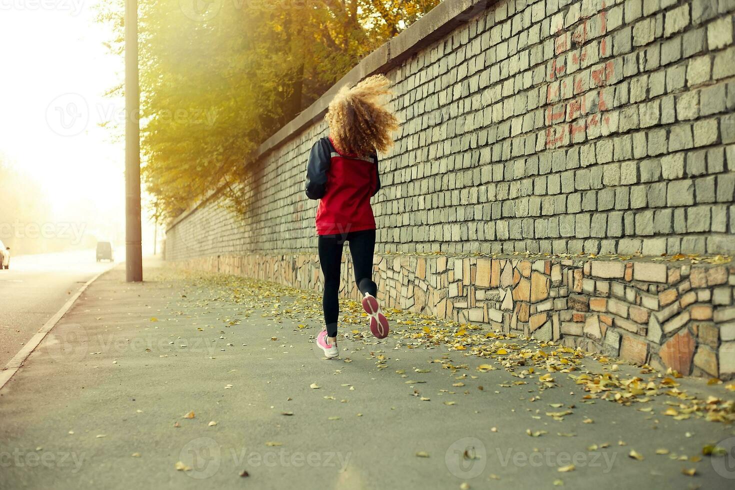 Fitness Girl running at sunset  city center photo