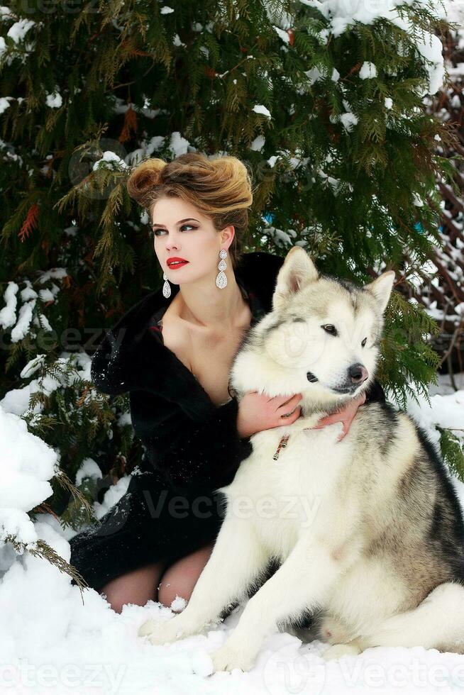 joven mujer con lobo perro en nieve foto