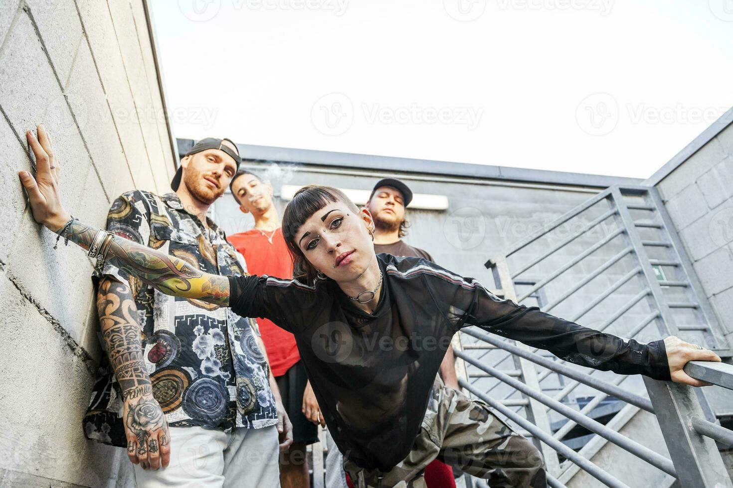 group of rappers posing on the metal stairs photo
