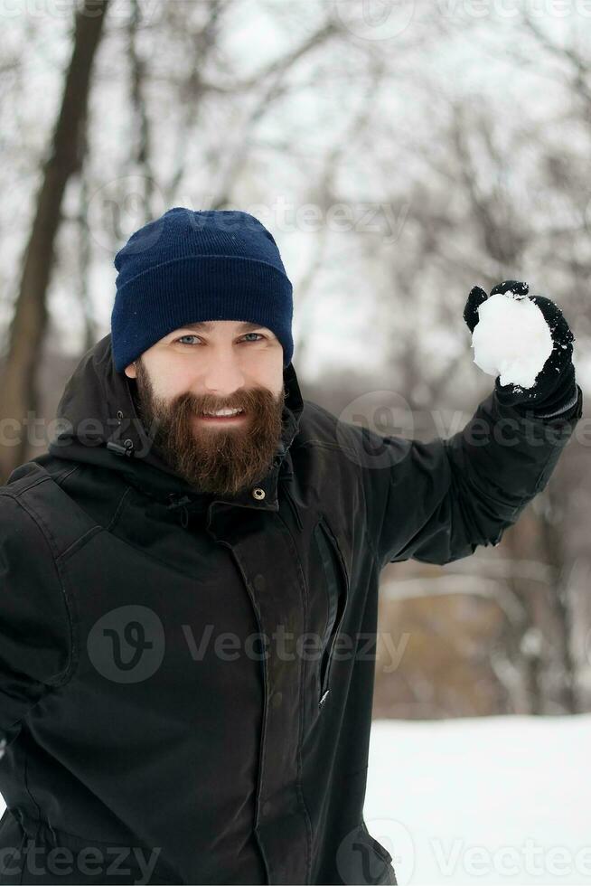 bearded guy playing snowballs photo