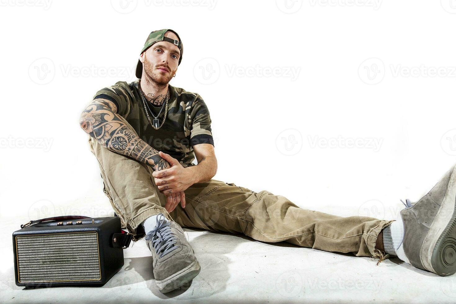 sitting tattooed rap singer posing in studio photo
