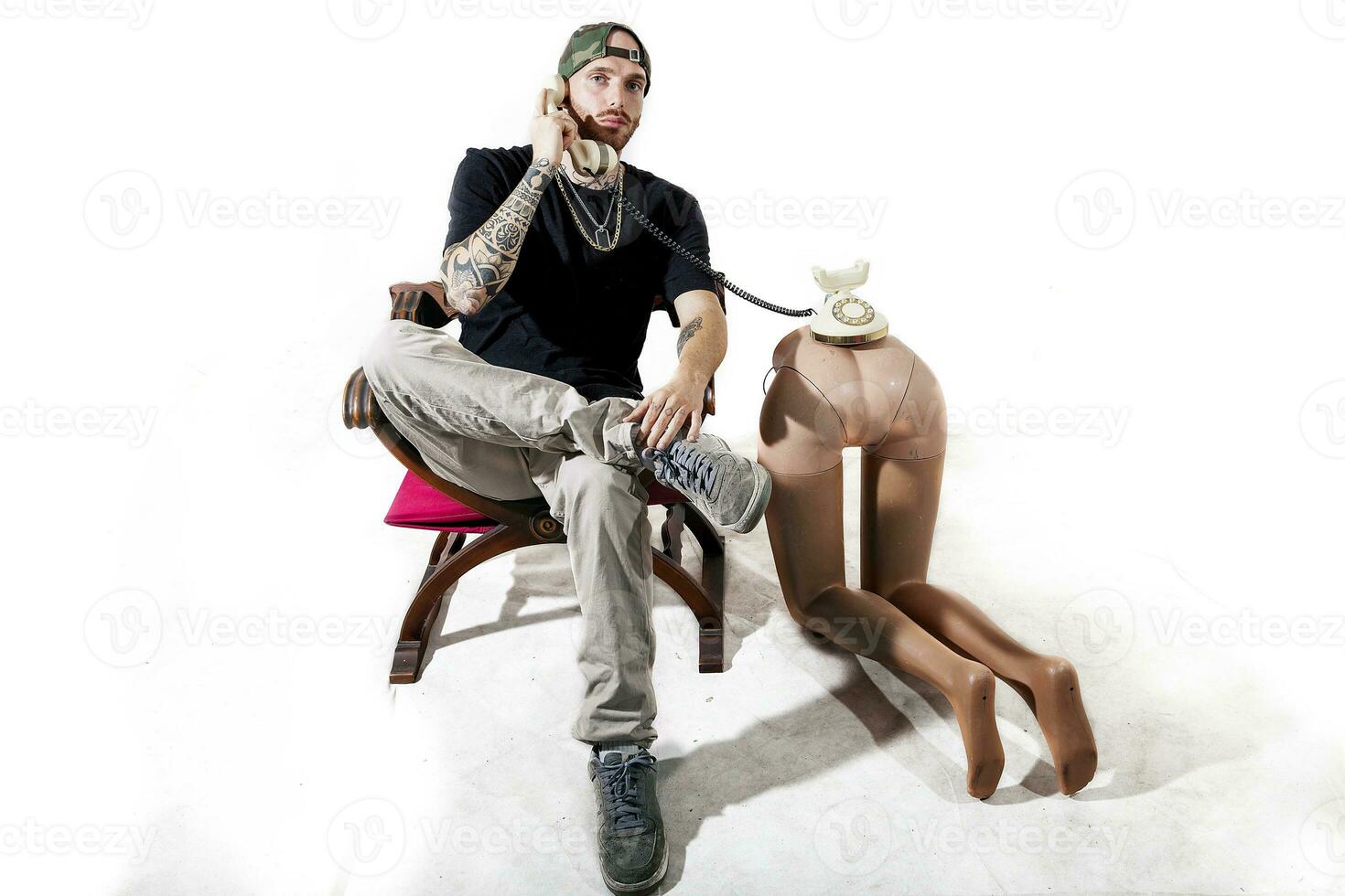 tattooed rap singer posing in studio with a female dummy photo