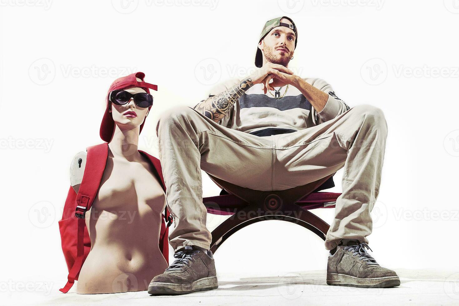 tattooed rap singer posing in studio with a female dummy photo