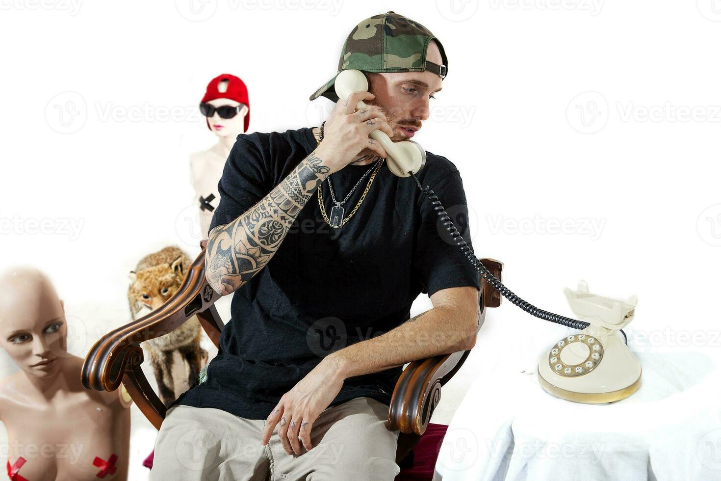 tattooed rap singer posing in studio with a female dummy photo