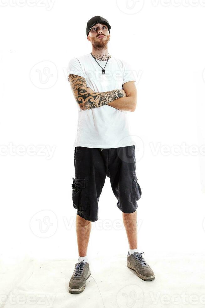 tattooed rap singer posing in studio on a white background photo