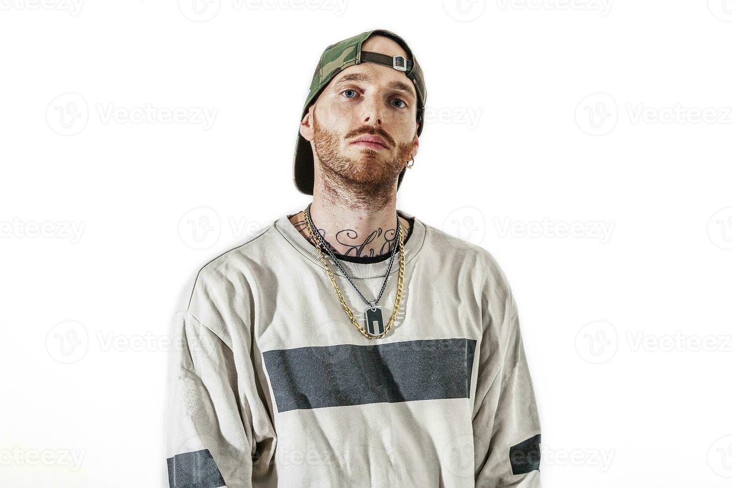 tattooed rap singer posing in studio on a white background photo