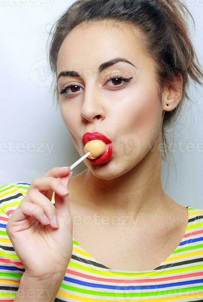 hermosa niña con caramelo en un palo foto