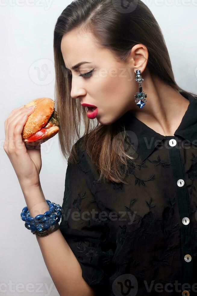 girl eating a big hamburger, studio photo