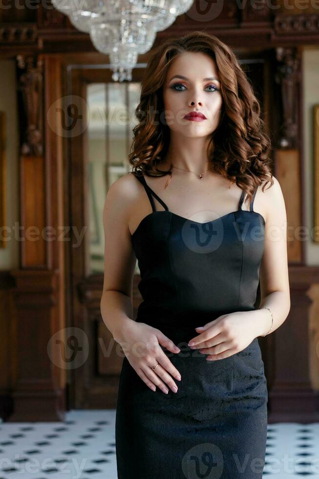 Elegant young woman in black evening dress photo