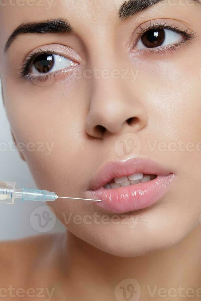 Attractive young woman gets cosmetic injection photo