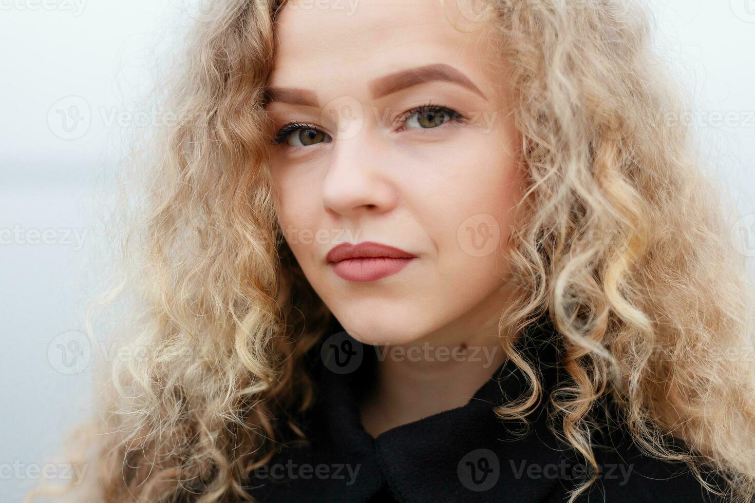 Beautiful young woman with curly hair, green eyes. photo