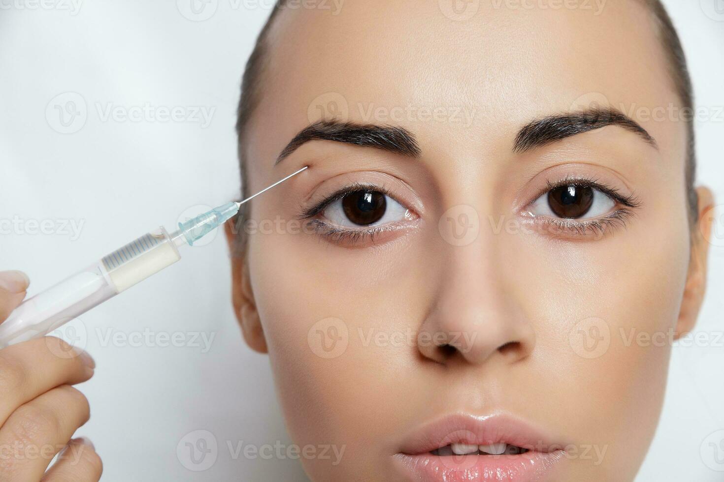 Attractive young woman gets cosmetic injection photo