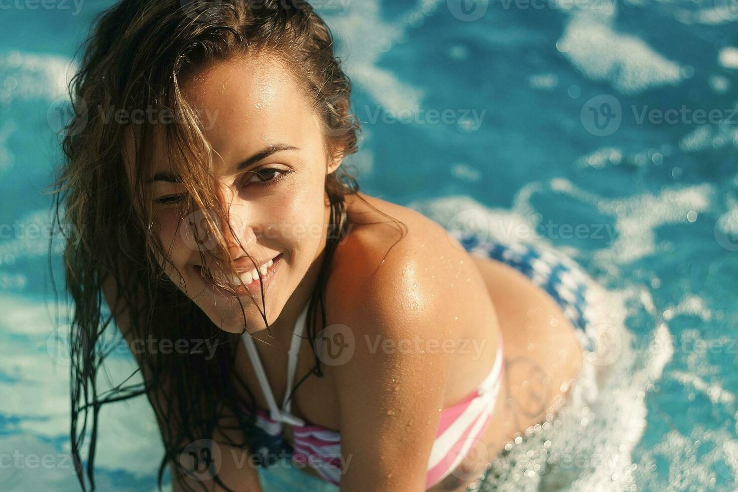 Young beautiful sexy blond girl in a bathing suit with glasses and ornaments around the pool close-up portrait photo