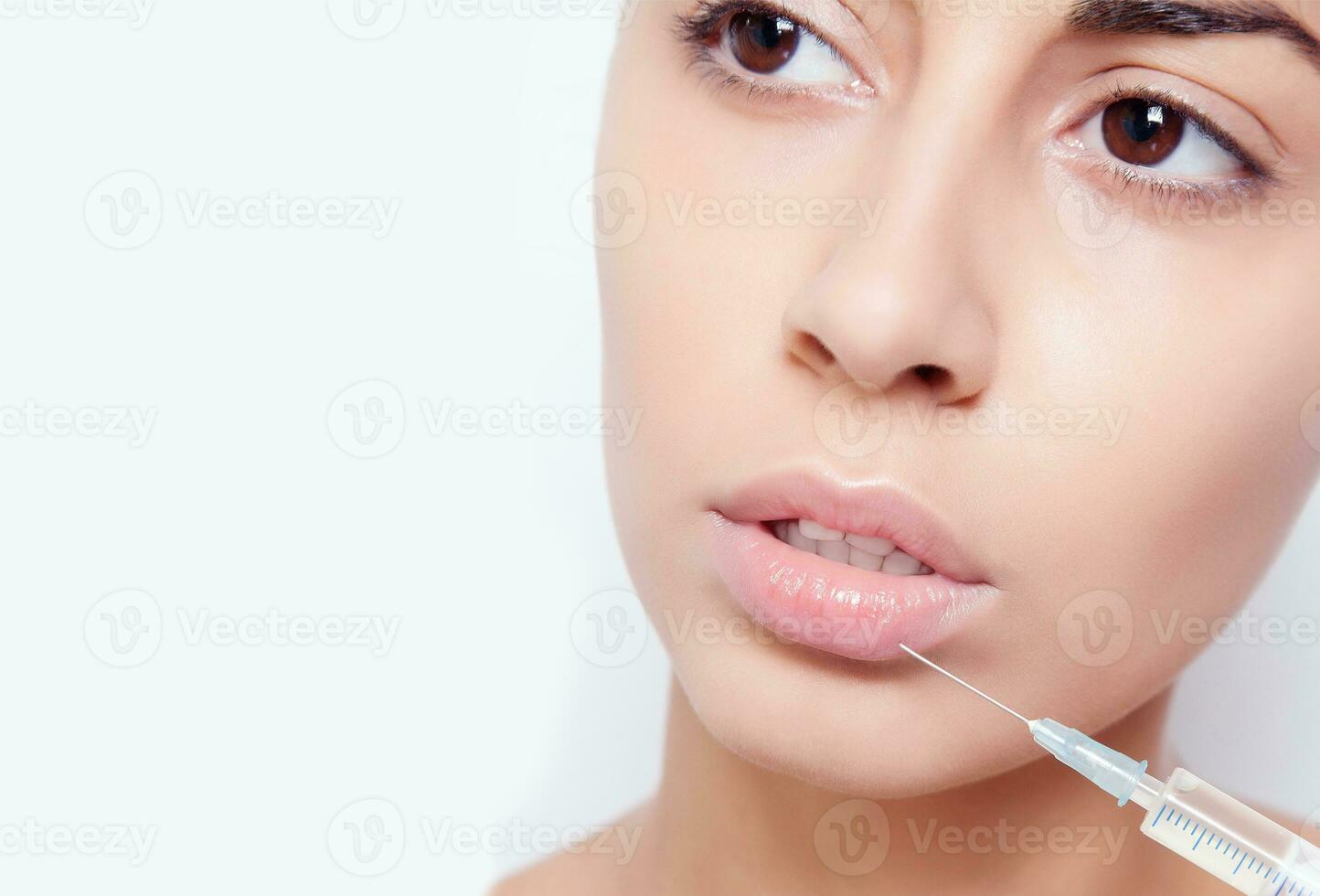 Attractive young woman gets cosmetic injection photo