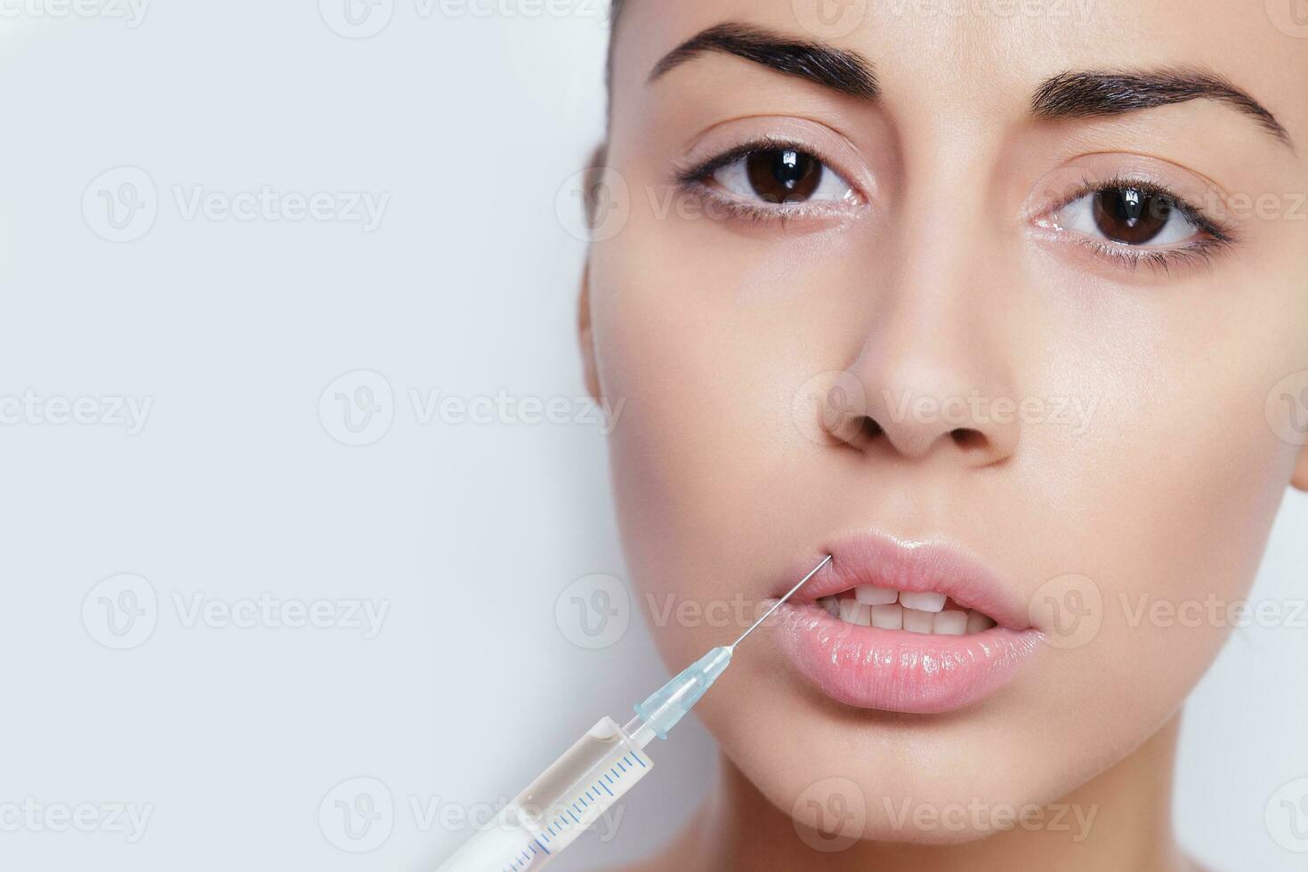 Attractive young woman gets cosmetic injection photo