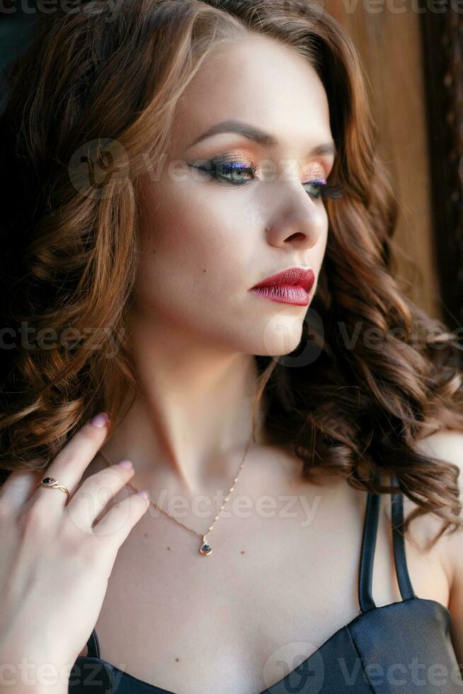 Elegant young woman in black evening dress photo