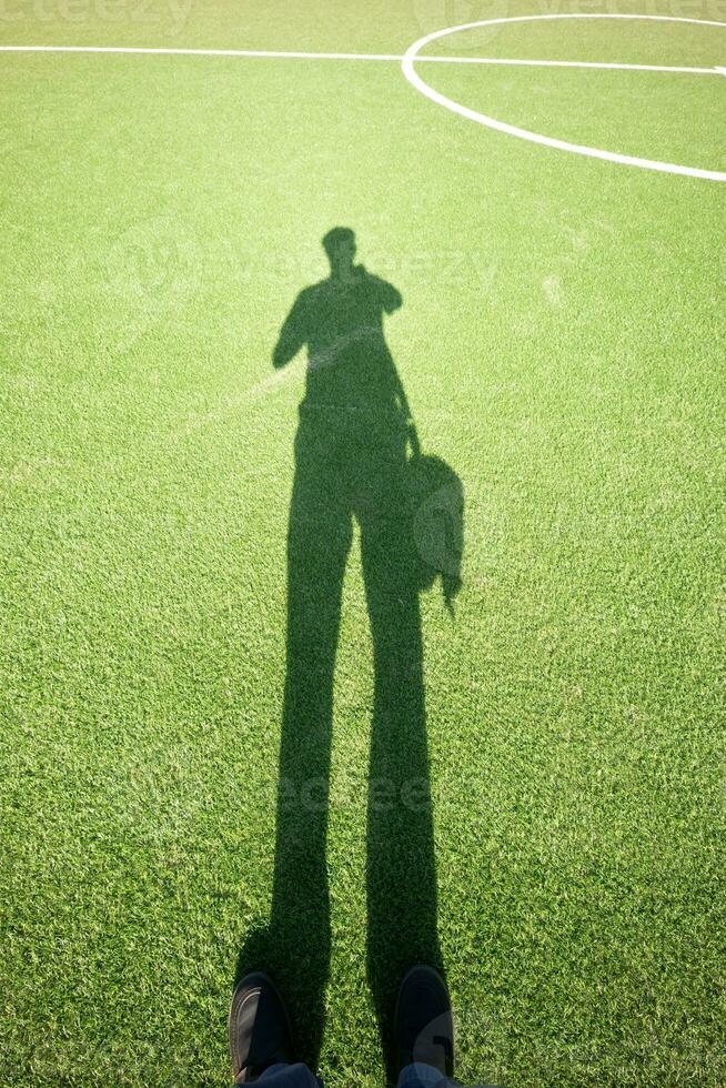 soccer field on grass with human shadow photo