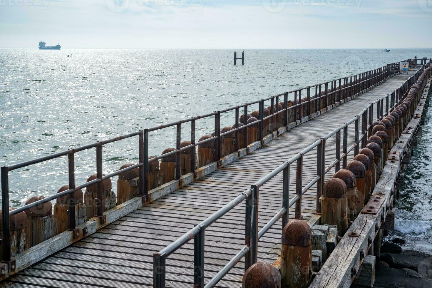 old rusty wooden pier to the sea photo