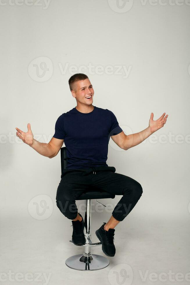 young fashion man sitting on a chair photo