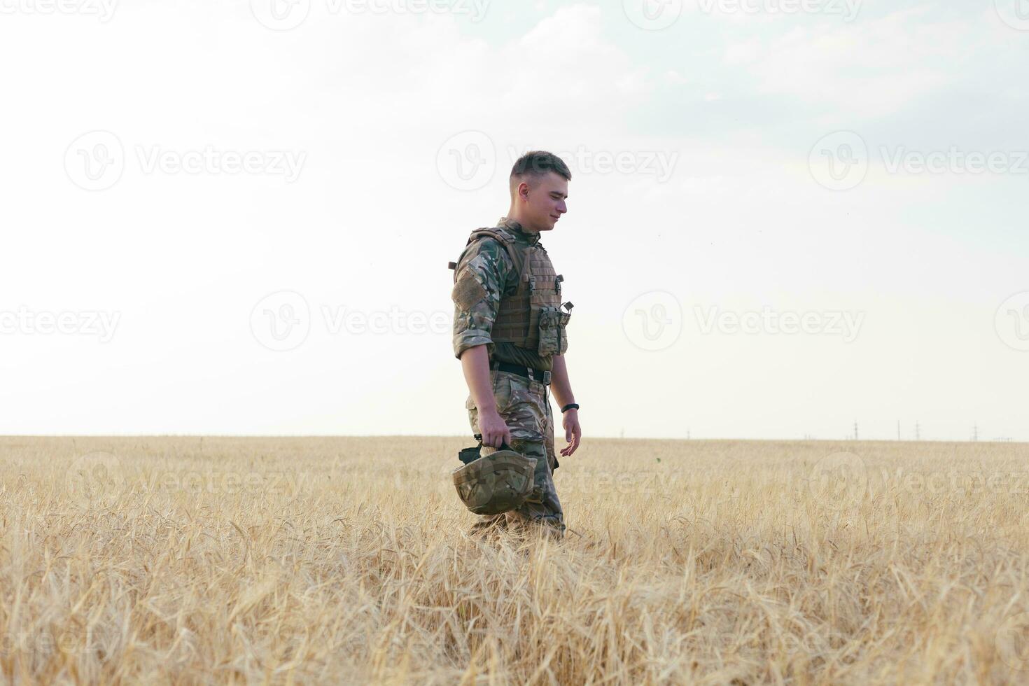 Soldier man standing against a field photo