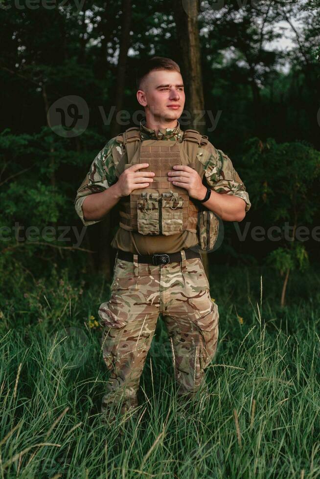 Soldier man standing against a field photo